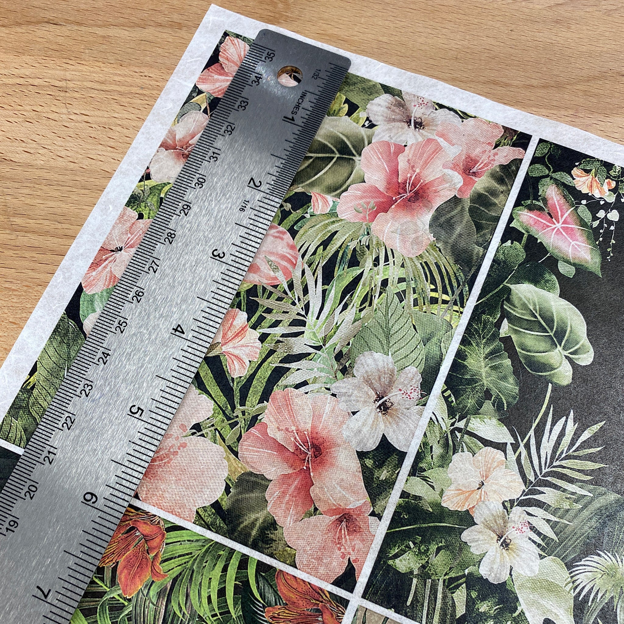 Decoupage Queen's Four Tropical Scenes A4 rice paper is shown against a wood background. A silver ruler on the paper shows a measurement of 5.8" for the height of one of the designs.