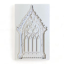 A light grey silicone mold of an ornate Gothic window is against a white background.