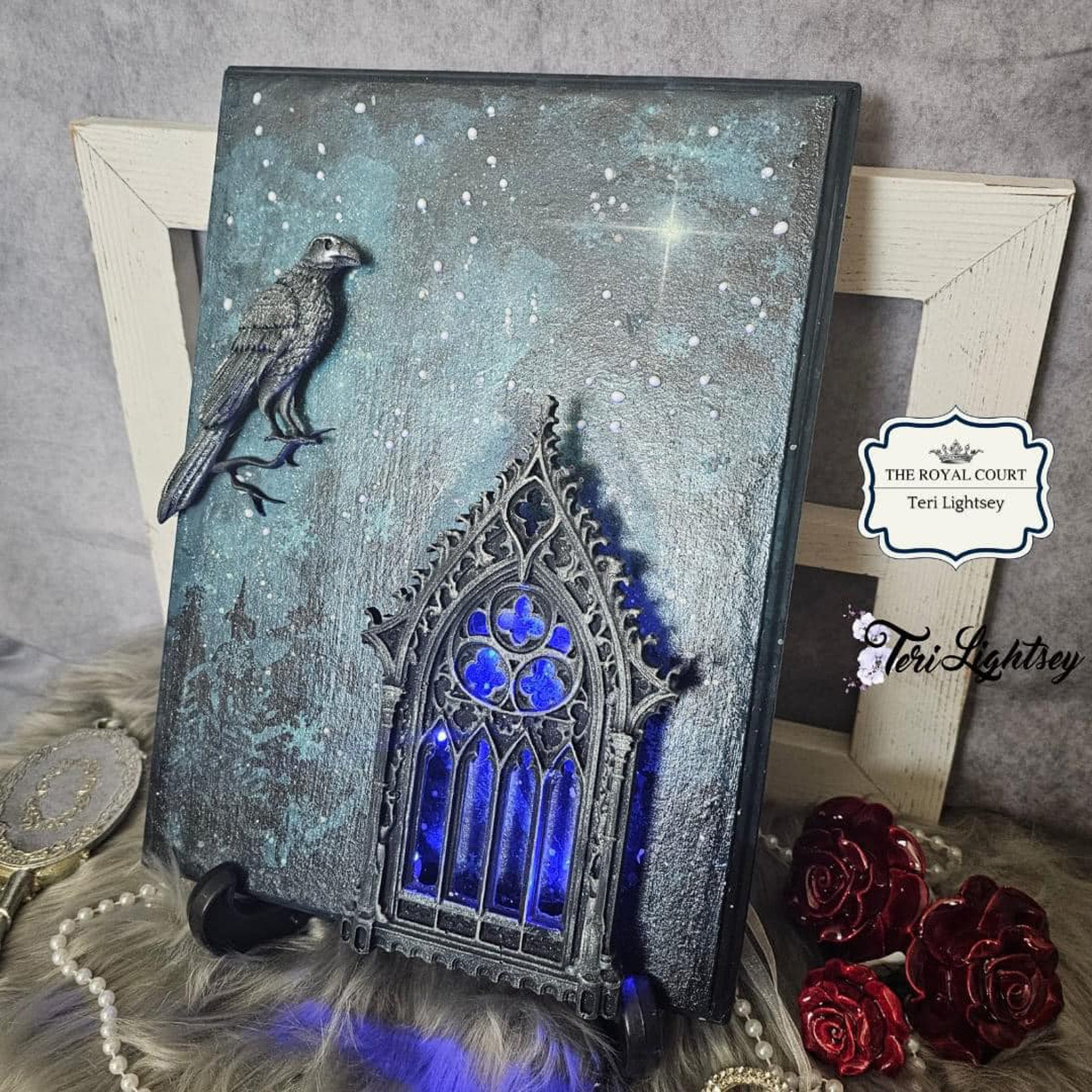 A painted dark night sky wood craft created by Teri Lightsey features Decoupage Queen's Gothic Window silicone mold casting on it. A casting of a raven is also on the craft.