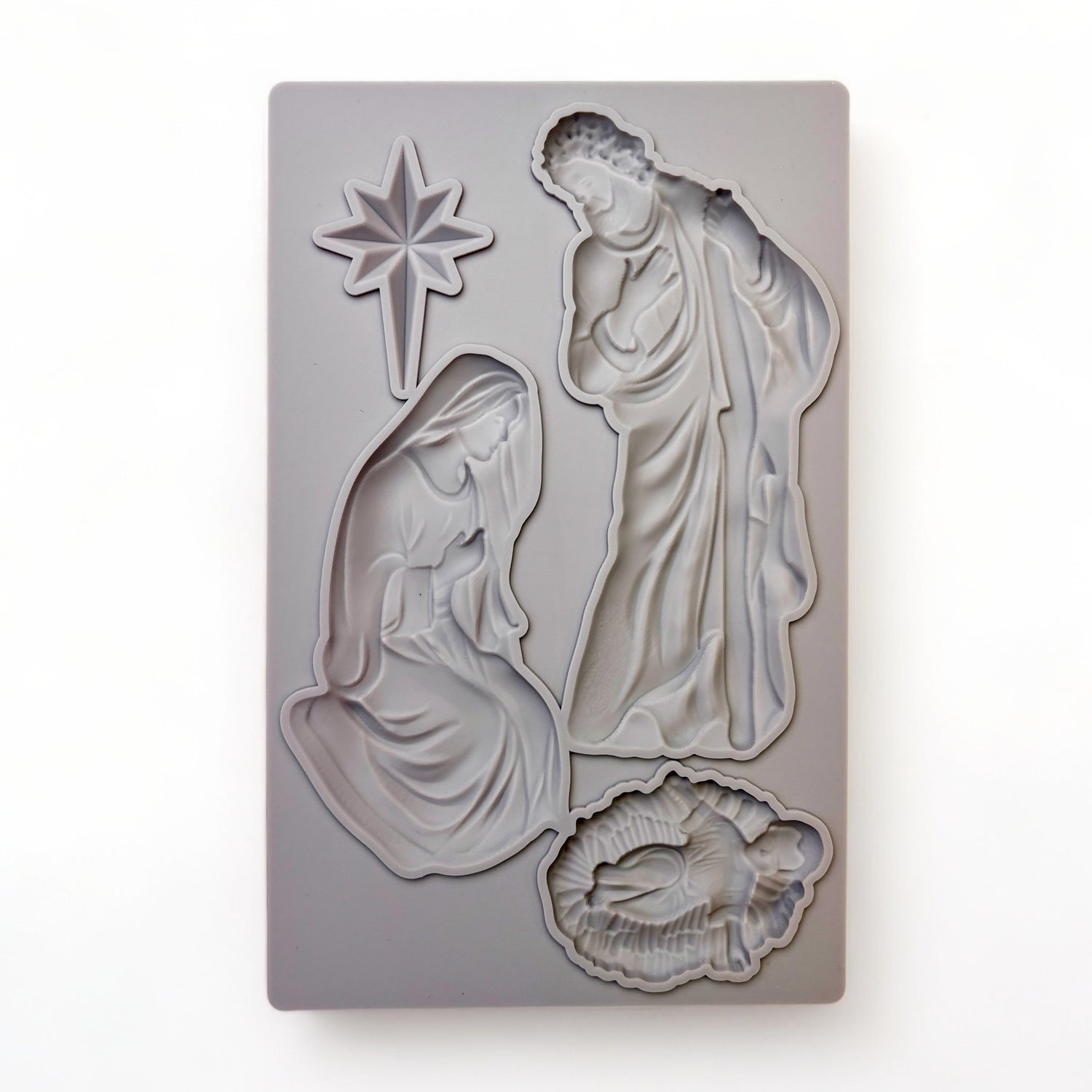 A beige silicone mold of the Holy Family and the Bethlehem Star is against a white background.