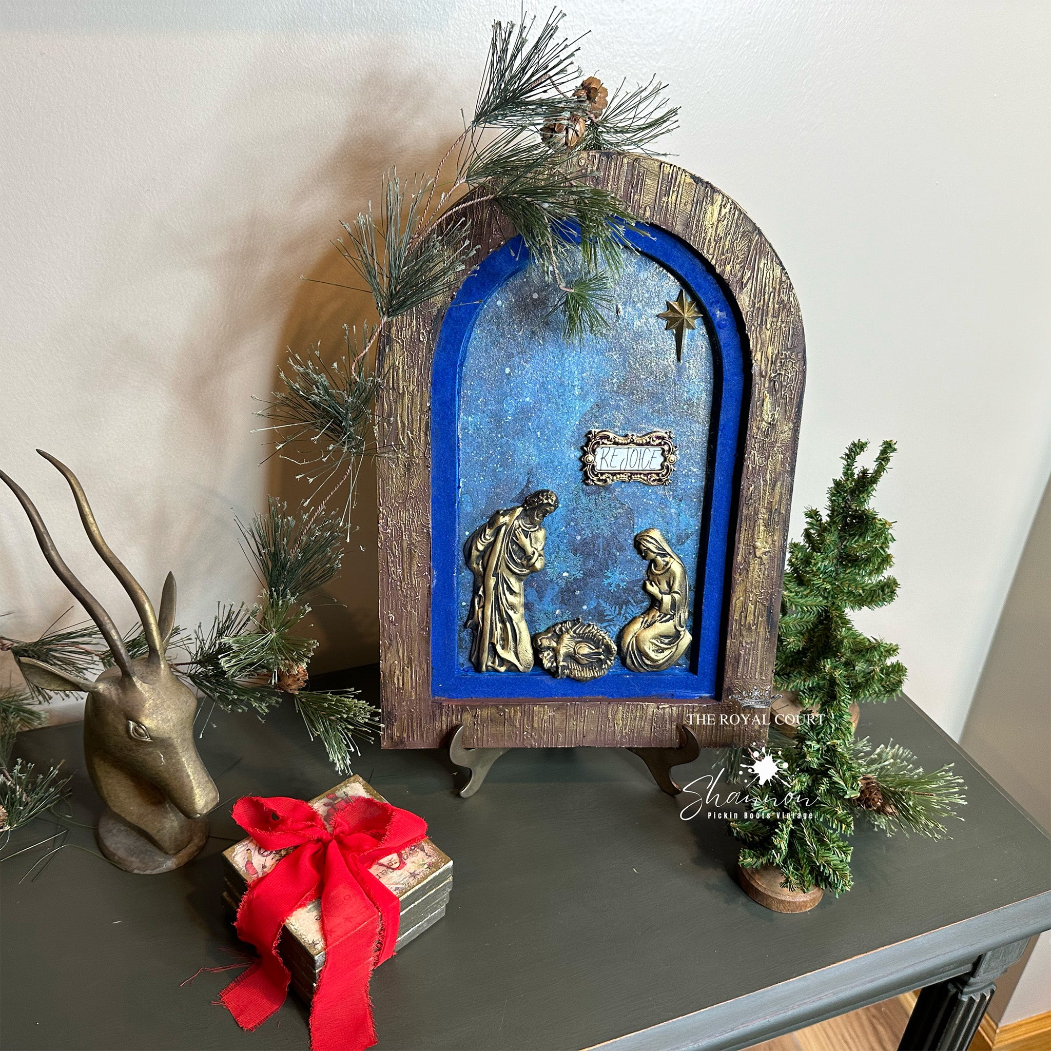 A wood arch frame craft features gold colored castings created from Decoupage Queen's Holy Family silicone mold.