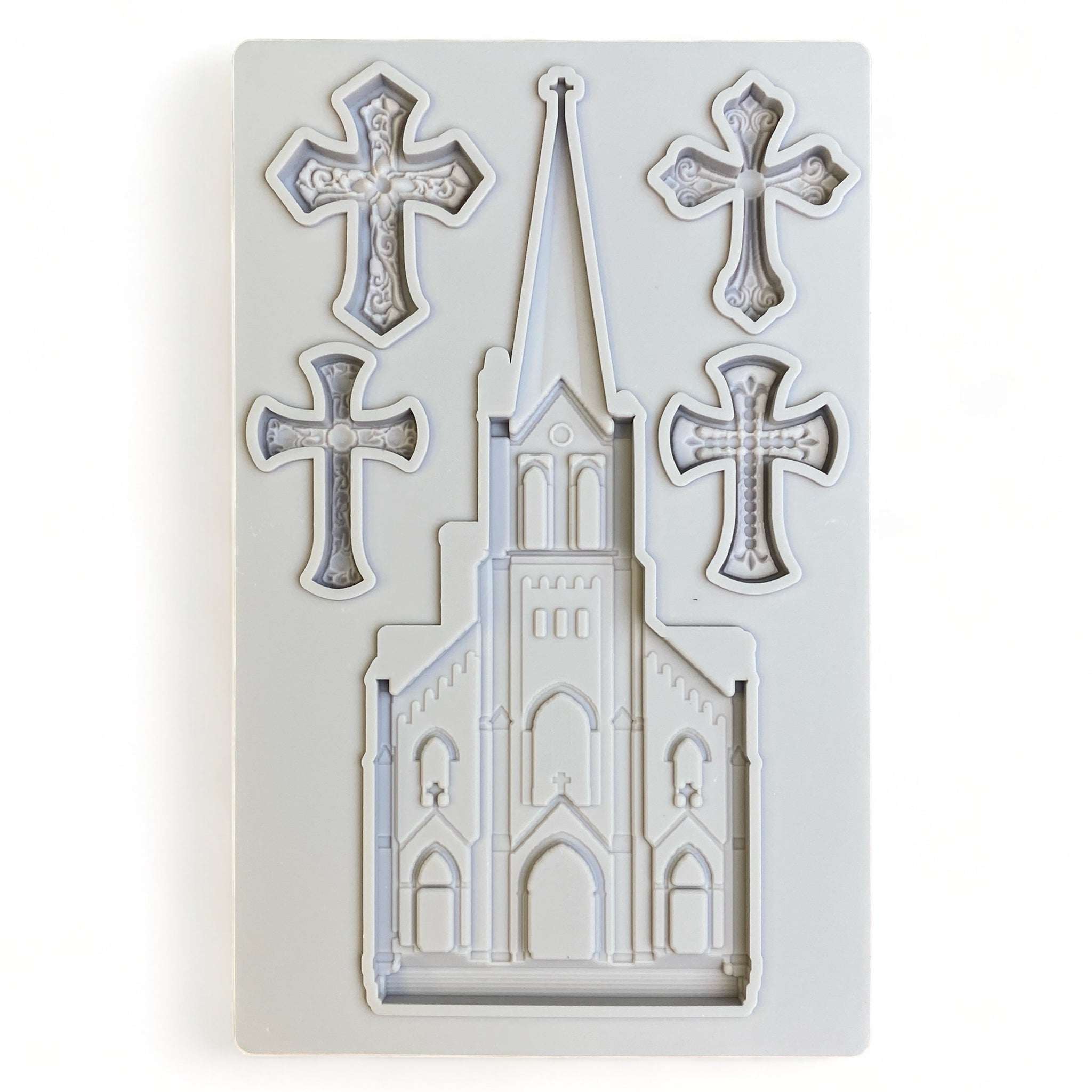 A grey silicone mold  of an old church with a tall steeple and 4 small ornate crosses is against a white background.