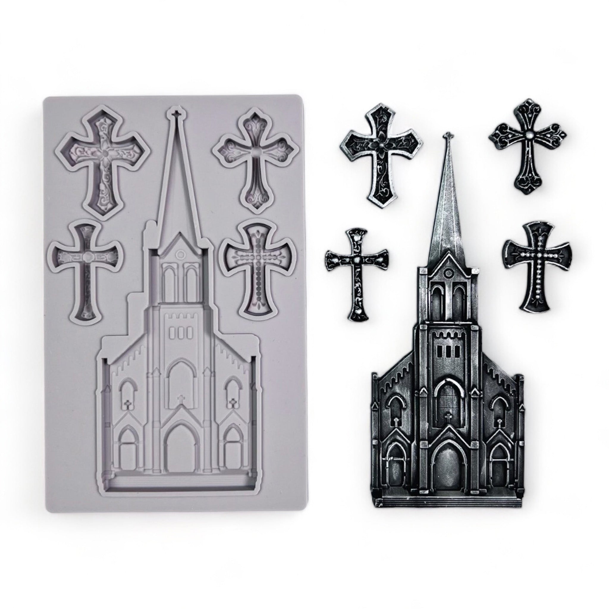 A grey silicone mold and silver colored castings of an old church with a tall steeple and 4 small ornate crosses are against a white background.