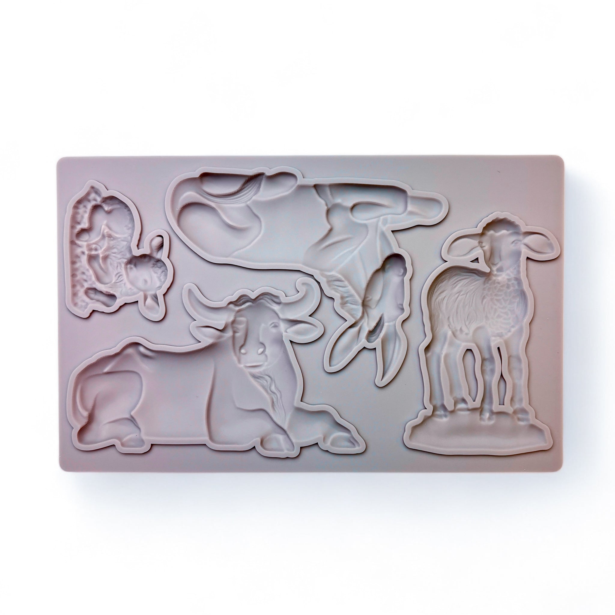 A beige silicone mold of 4 nativity animals are against a white background.