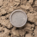 Brown Dixie Dirt in a container on a dry, cracked soil background