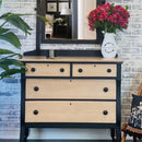 A 4-drawer dresser with an attached mirror has natural wood and features Dixie Belle's Anchor Silk All-In-One Mineral Paint.