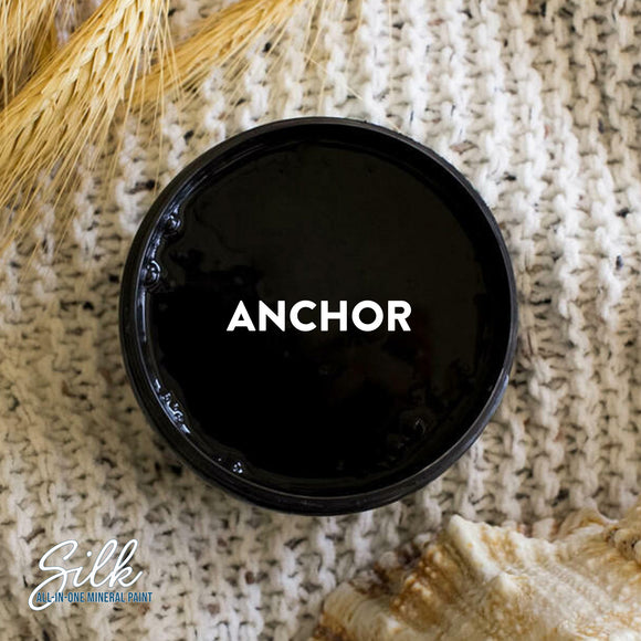 An arial view of an open container of Dixie Belle Paint Company's Anchor Silk All-In-One Mineral Paint is shown with white text reading Anchor