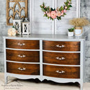 A large 6-drawer dresser refurbished by Perception an eye for Treasures features Dixie Belle's Baja Gray Silk All-In-One Mineral Paint with dark natural wood drawers.