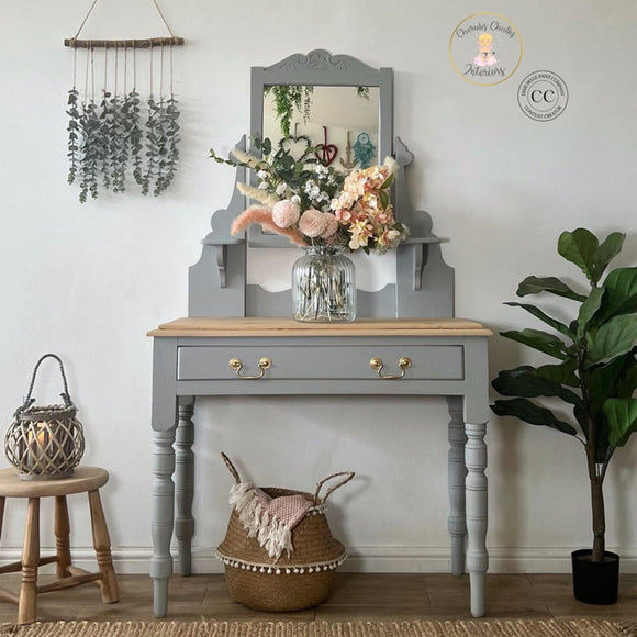A vintage vanity desk refurbished by Cherubs Chalks Interiors features Dixie Belle's Baja Gray Silk All-In-One Mineral Paint.