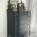 An 8-drawer chest dresser refurbished by Black Lab Furniture Revival features Dixie Belle's Black Sands Silk All-In-One Mineral Paint.