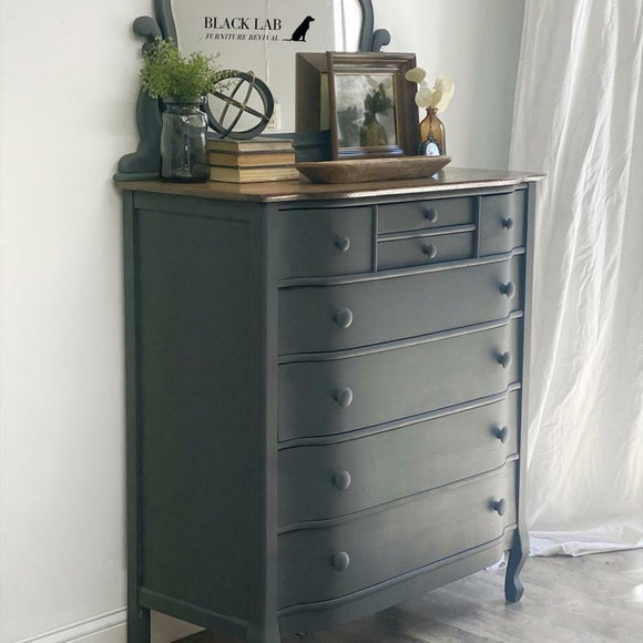 An 8-drawer chest dresser refurbished by Black Lab Furniture Revival features Dixie Belle's Black Sands Silk All-In-One Mineral Paint.