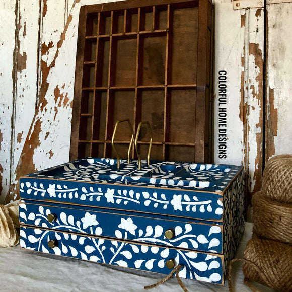 A vintage table top jewelry box refurbished by Colorful Home Designs features Dixie Belle's Cape Current Silk All-In-ne Mineral Paint with a white floral stencil design.