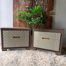 Two wooden dressers with patterned doors and gold handles on a textured surface.
