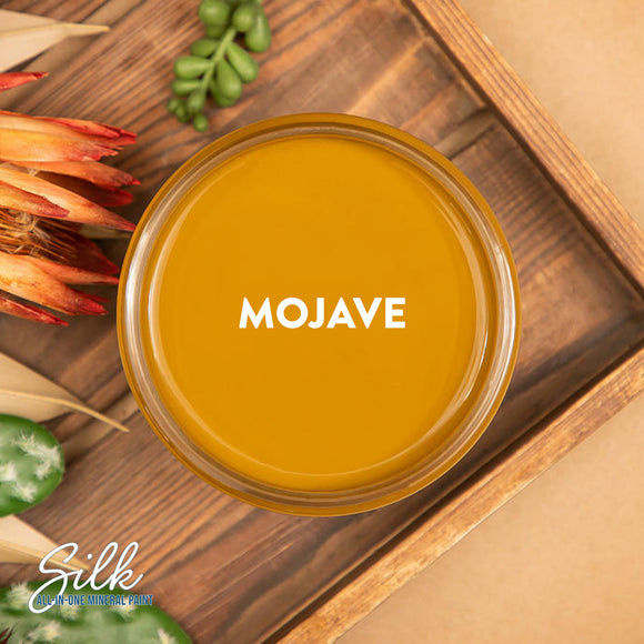 An arial view of an open container of Dixie Belle Paint Company's Mojave Silk All-In-One Mineral Paint is shown with white text reading Mojave.