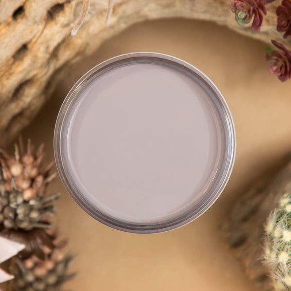An arial view of an open container of Dixie Belle Paint Company's Morning Sunrise All-In-One Silk Paint is on a sand brown table with natural driftwood.