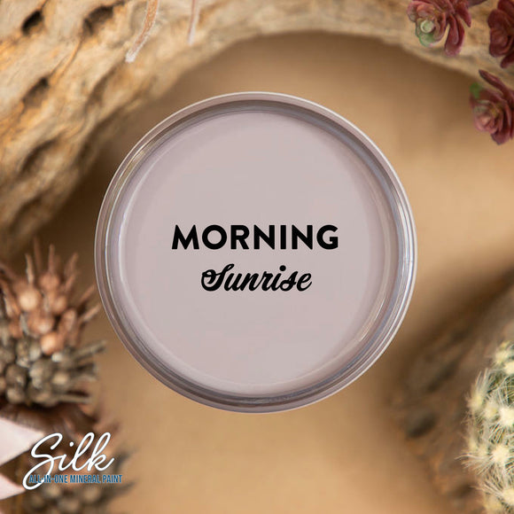 An arial view of an open container of Dixie Belle Paint Company's Morning Sunrise Silk All-In-One Mineral Paint is shown with black text reading Morning Sunrise.