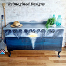 A vintage buffet table refurbished by Reimagined Designs has a hand-painted beach scene that features Dixie Belle's Nautical Silk All-In-One Mineral Paint.