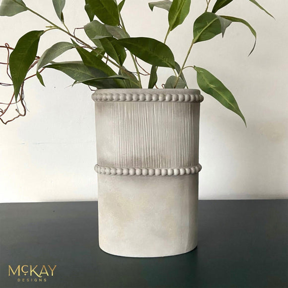 A cylindrical vase refurbished by McKay Designs features Dixie Belle's Oyster Silk All-In-One Mineral Paint.