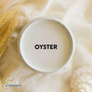 An arial view of an open container of Dixie Belle Paint Company's Oyster Silk All-In-One Mineral Paint is shown with black text reading Oyster.