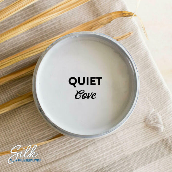 An arial view of an open container of Dixie Belle Paint Company's Quiet Cove Silk All-In-One Mineral Paint is shown with black text reading Quiet Cove.