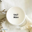 An arial view of an open container of Dixie Belle Paint Company's Salt Water Silk All-In-One Mineral Paint is shown with black text reading Salt Water.