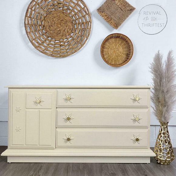 A 3-drawer and 1 cubby dresser refurbished by Revival of the Thriftest features Dixie Belle's Sand Castle Silk All-In-One Mineral Paint.