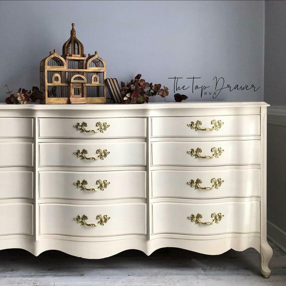 A large vintage 12-drawer dresser refurbished by The Top Drawer features Dixie Belle's Sun Kissed Silk All-In-One Mineral Paint.