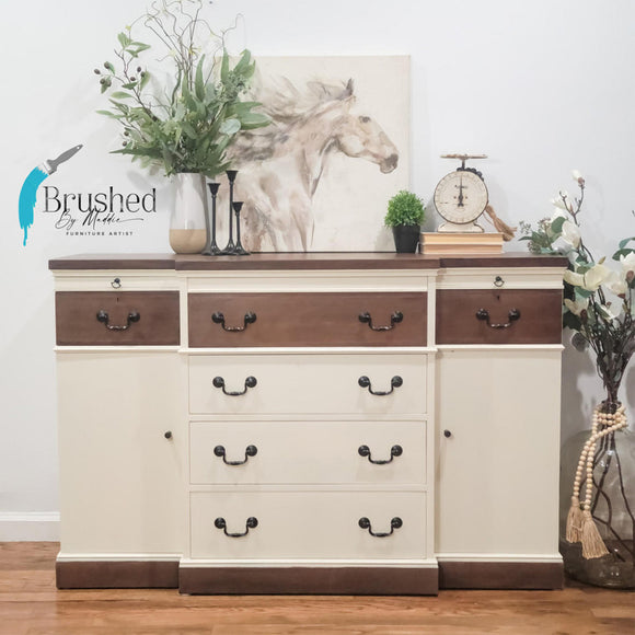 A buffet cabinet refurbished by Brushed by Maddie Furniture Artist has natural wood accents and features Dixie Belle's Sun Kissed Silk All-In-One Mineral Paint.