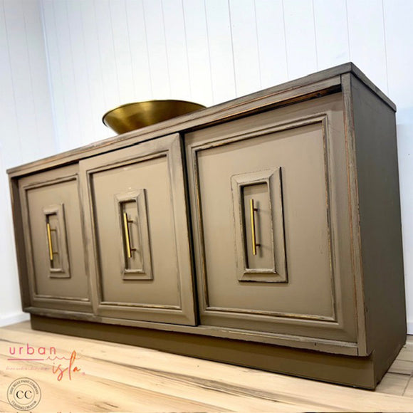 Gray sideboard with gold handles on a wooden floor.