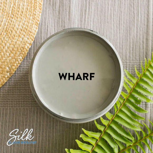 An arial view of an open container of Dixie Belle Paint Company's Wharf Silk All-In-One Mineral Paint is shown with black text reading Wharf.