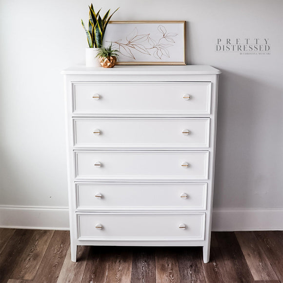 A 5-drawer chest dresser refurbished by Pretty Distressed by Christina Muscari features Dixie Belle's Whitecap Silk All-In-One Mineral Paint.