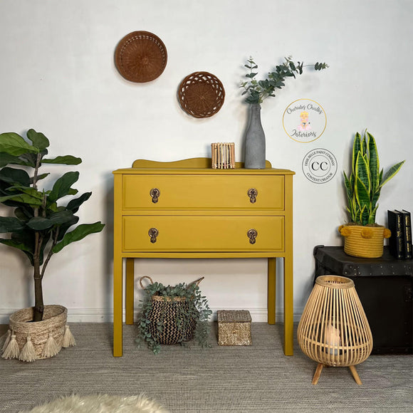 A vintage 2-drawer high leg dresser refurbished by Cherubs Chalks Interiors  features Dixie Belle's Yellowstone Silk All-In-One Mineral Paint.