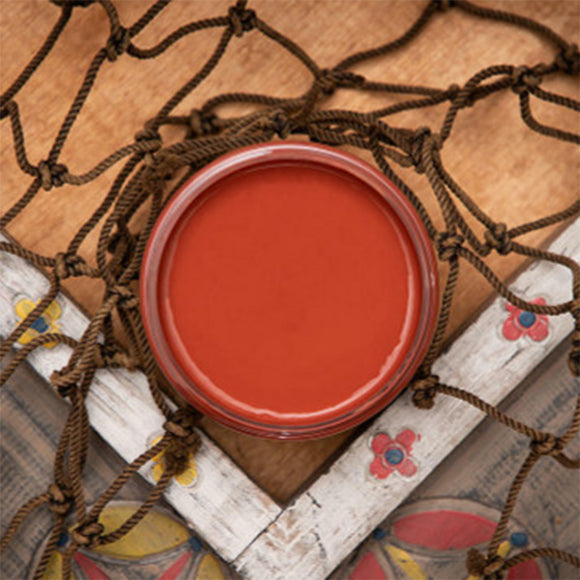 An arial view of an open container of Dixie Belle Paint Company's Rusty Nail Chalk Mineral Paint is sitting on a wood table and surrounded by brown netting.