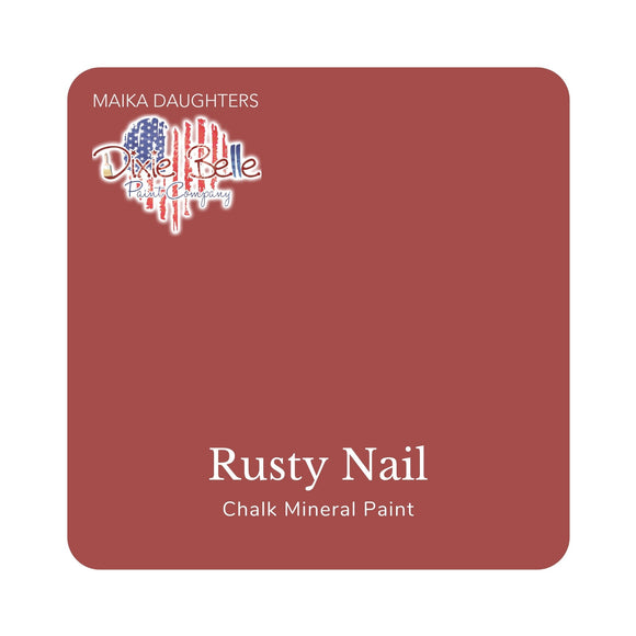 A square swatch card of Dixie Belle Paint Company’s Rusty Nail Chalk Mineral Paint. This color is a burnt orange hue.
