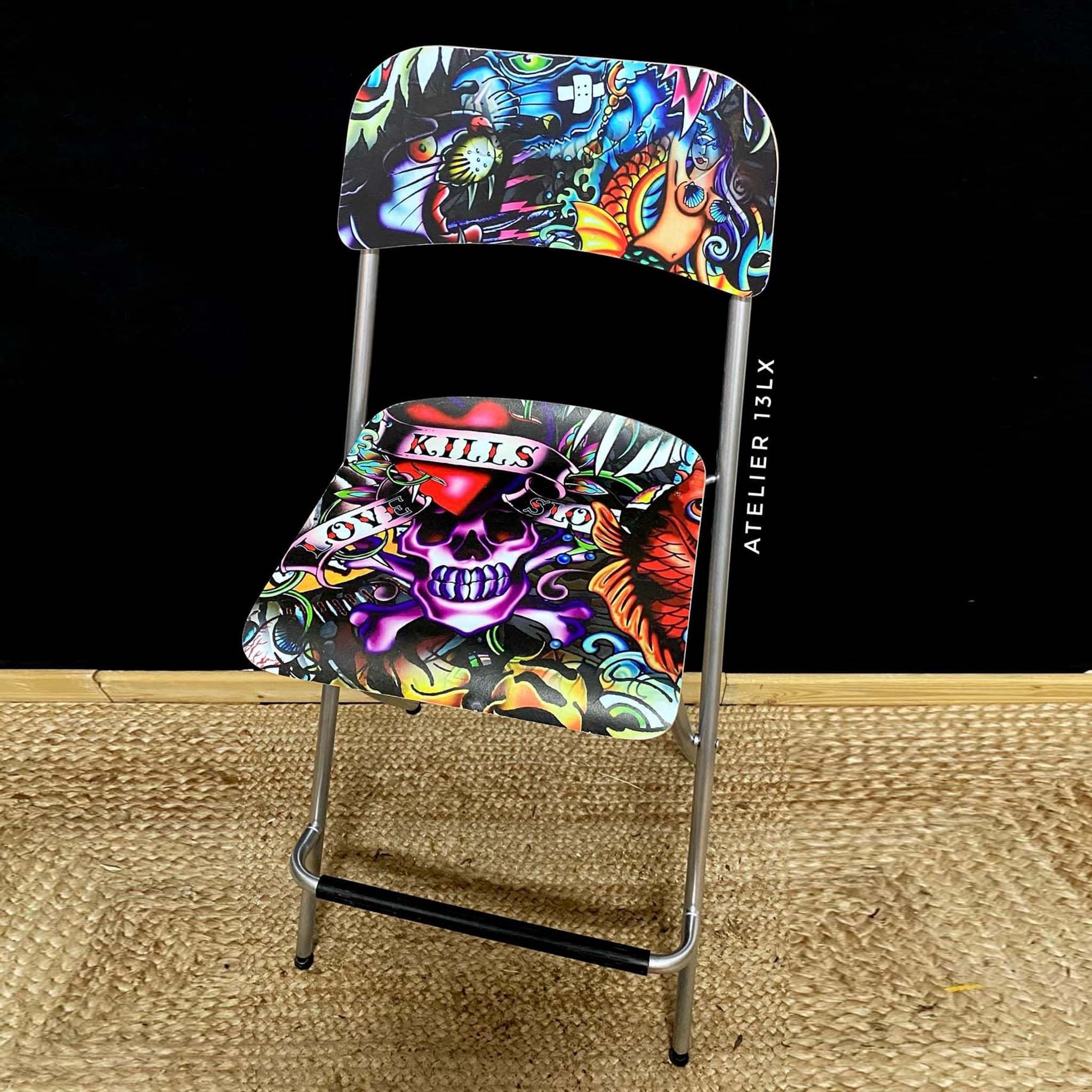 A vintage metal folding chair refurbished by Atelier 13LX features Belles & Whistles Vintage Tattoo A1 rice paper on its hard platic back and seat.
