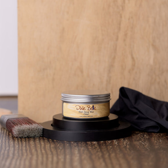 Jar of Dixie Belle wood finish on a wooden surface with a brush and cloth.