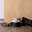 Jar of Dixie Belle wood finish on a wooden surface with a brush and cloth.