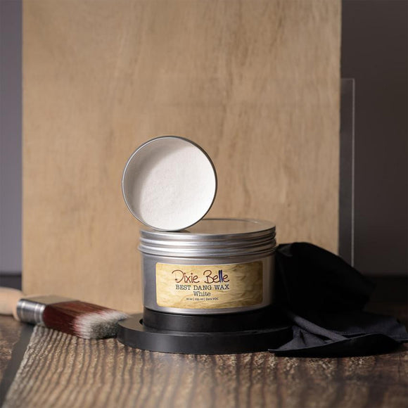 Open tin of wax with 'Dixie Belle' label on a wooden surface