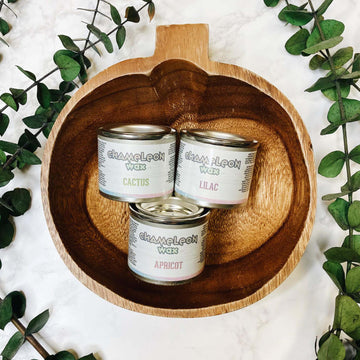 Three 1.3 oz (40ml) containers of Dixie Belle's Chameleon Gilding Wax are inside of a wood pumpkin tray against a white background with green vines.