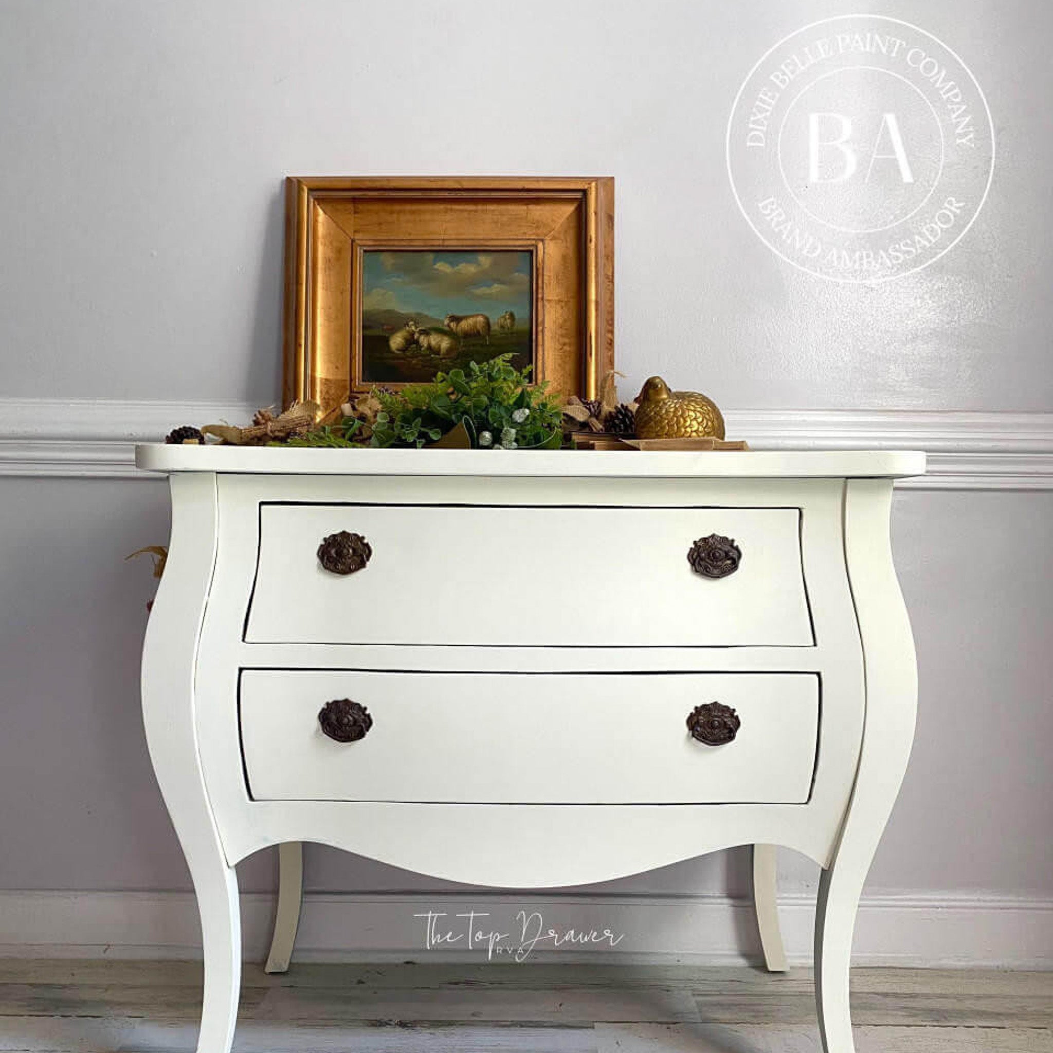 A vintage Bombay style 2-drawer dresser refurbished by The Top Drawer is painted in Dixie Belle's Cucumber Ice chalk mineral paint.