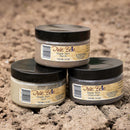 Three jars of Dixie Belle Dixie Dirt on a textured brown background