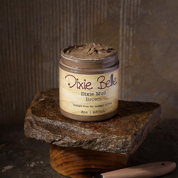 Jar of Dixie Belle Dixie Mud Brown on a stone surface with a rustic background