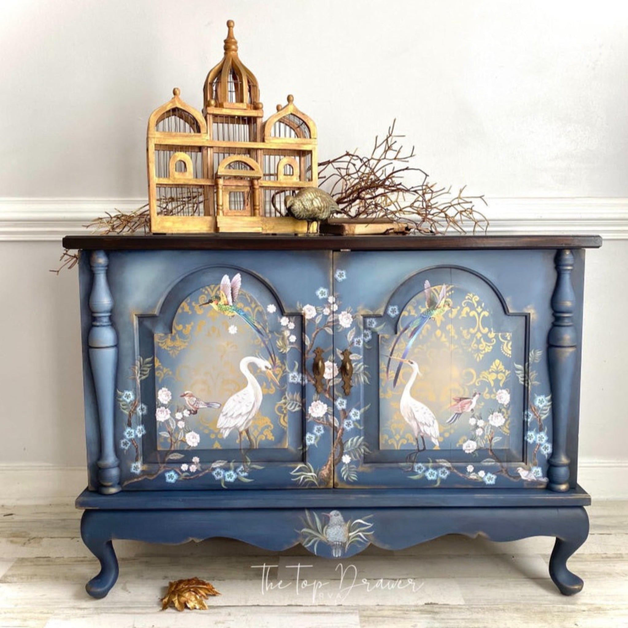 A vintage buffet cabinet refurbished by The Top Drawer is painted blue and features Belles & Whistles' Chinoiserie rub-on transfer on the 2 front doors.