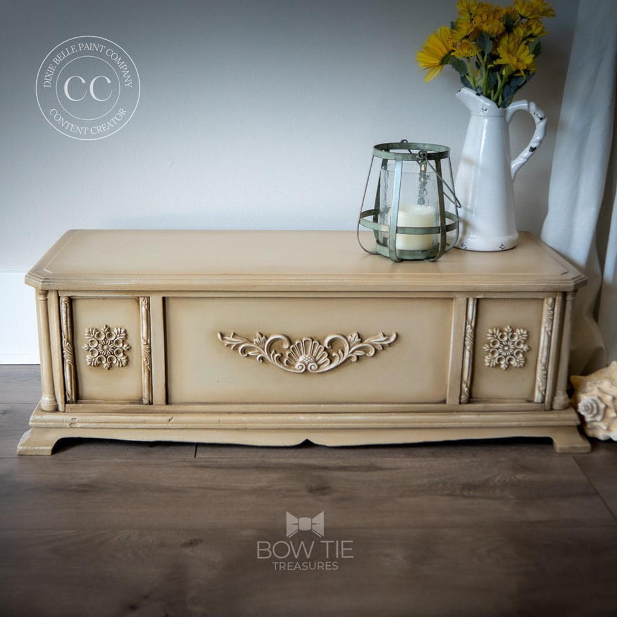 A small vintage table storage box refurbished by Bow Tie Treasures is painted light sandy brown and features Dixie Belle Paint's Van Dyke Brown Glaze on it to accent detailed areas.