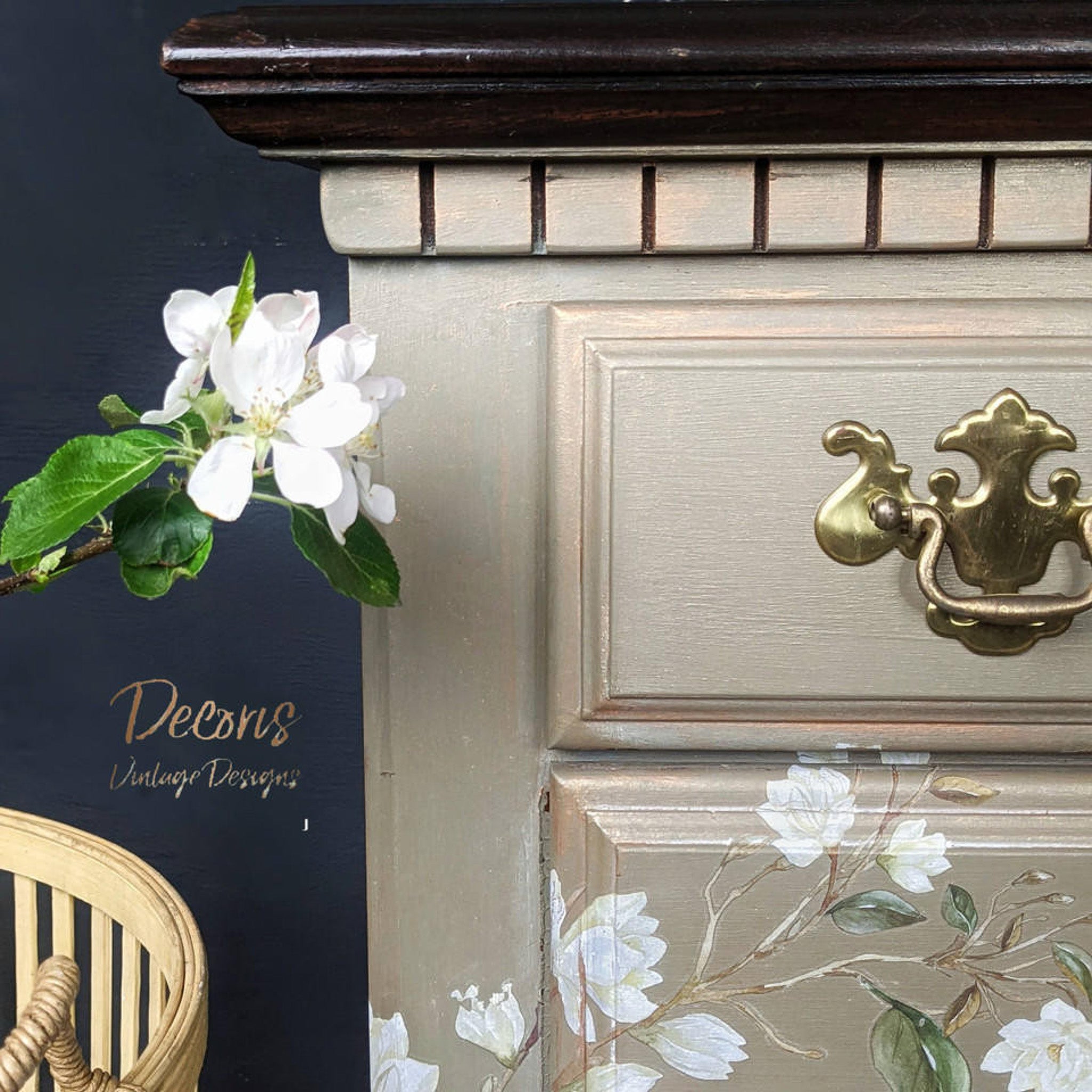 A close-up view of a vintage dresser refurbished by Decoris Vintage Designs is painted beige and features Dixie Belle Paint's Copper Bronze Glaze to accent corners and recessed areas.