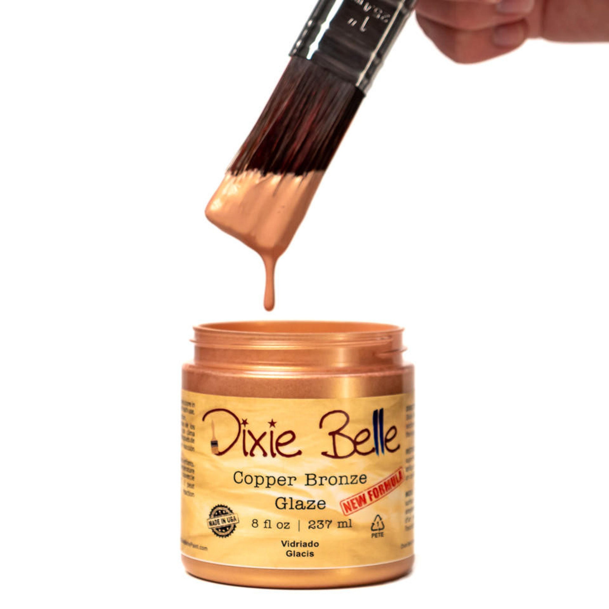 An open container of an 8oz/237ml Dixie Belle Copper Bronze Glaze with a dripping paintbrush above it is against a white background.