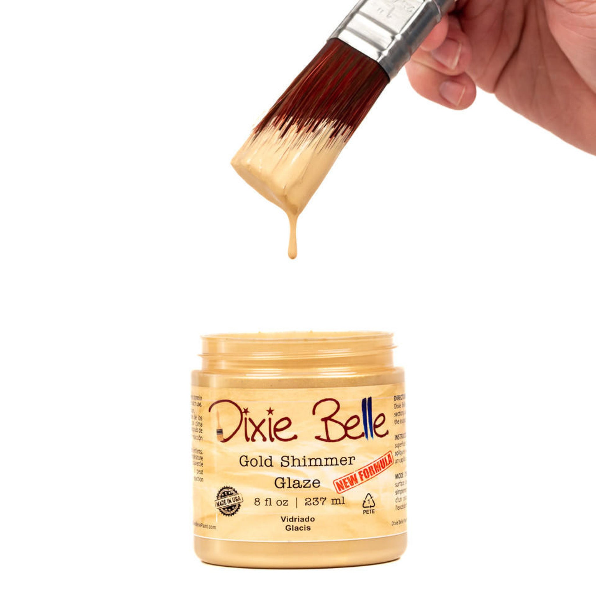 An open container of an 8oz/237ml Dixie Belle Gold Shimmer Glaze with a dripping paintbrush above it is against a white background.