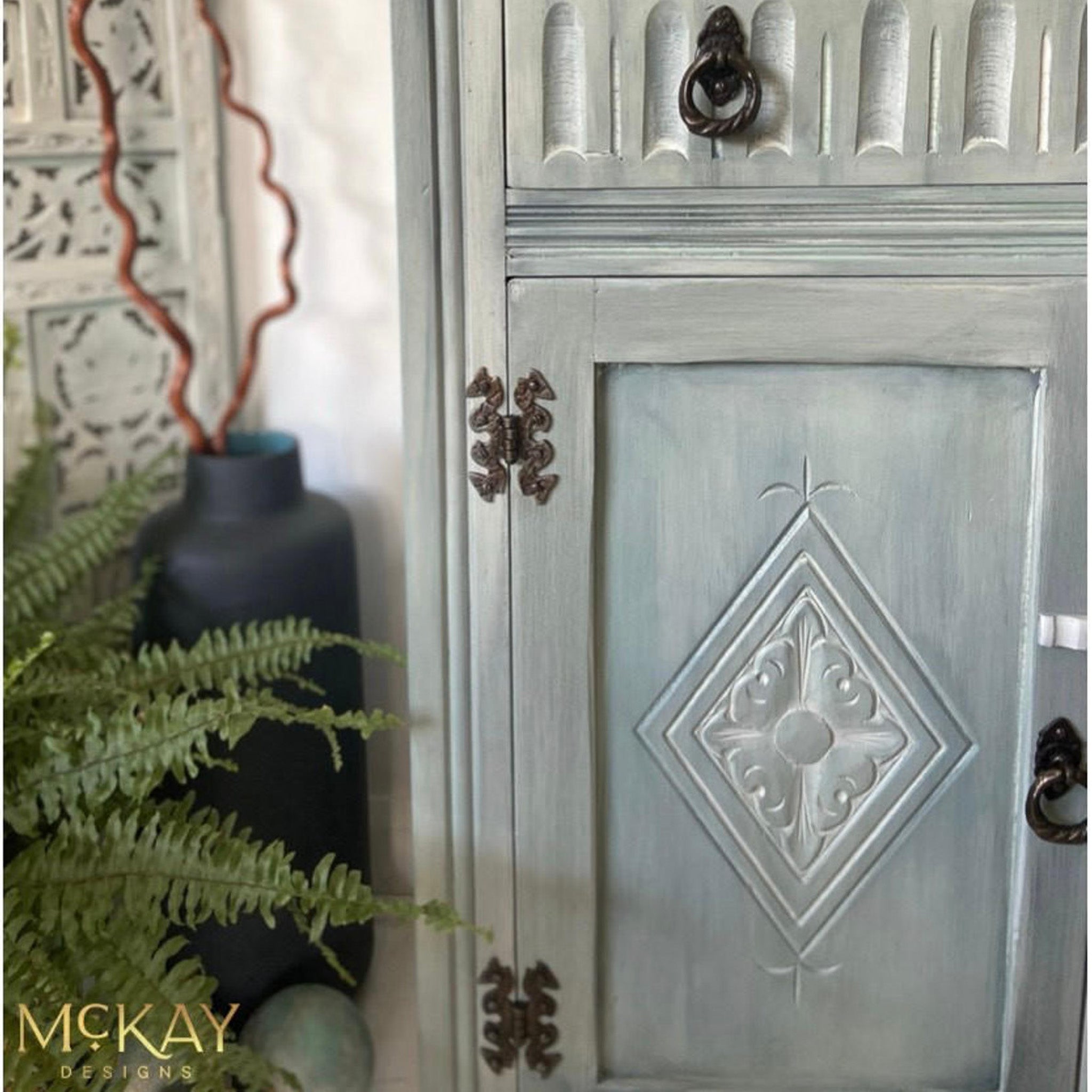 A close-up of a vintage dresser refurbished by McKay Designs is painted light grey and features Dixie Belle Paint's Whitewash Glaze on it.