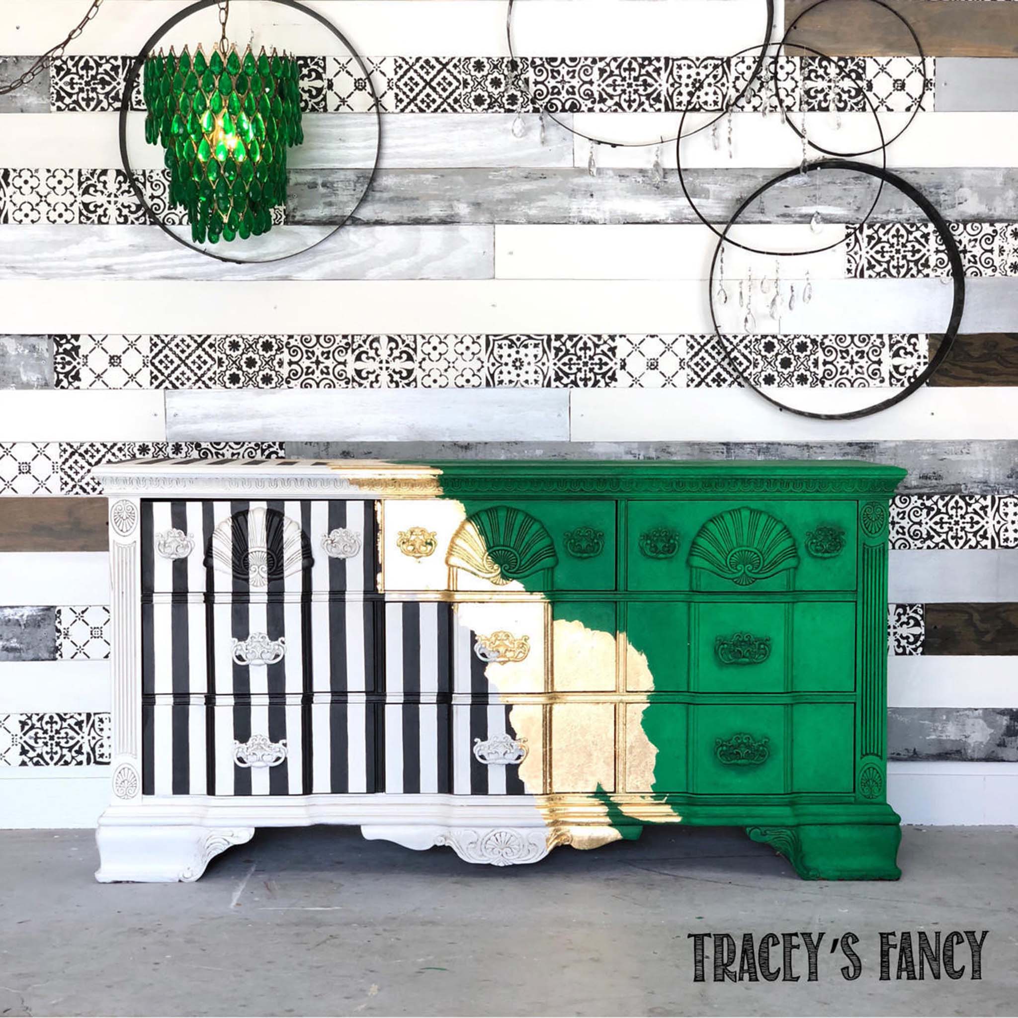A vintage large 9 drawer dresser refurbished by Tracey's Fancy is painted half green on the right and white with black verticle stripes on the left with gold leaf down the middle. The green is fully accented using Dixie Belle Paint's Grunge Glaze.