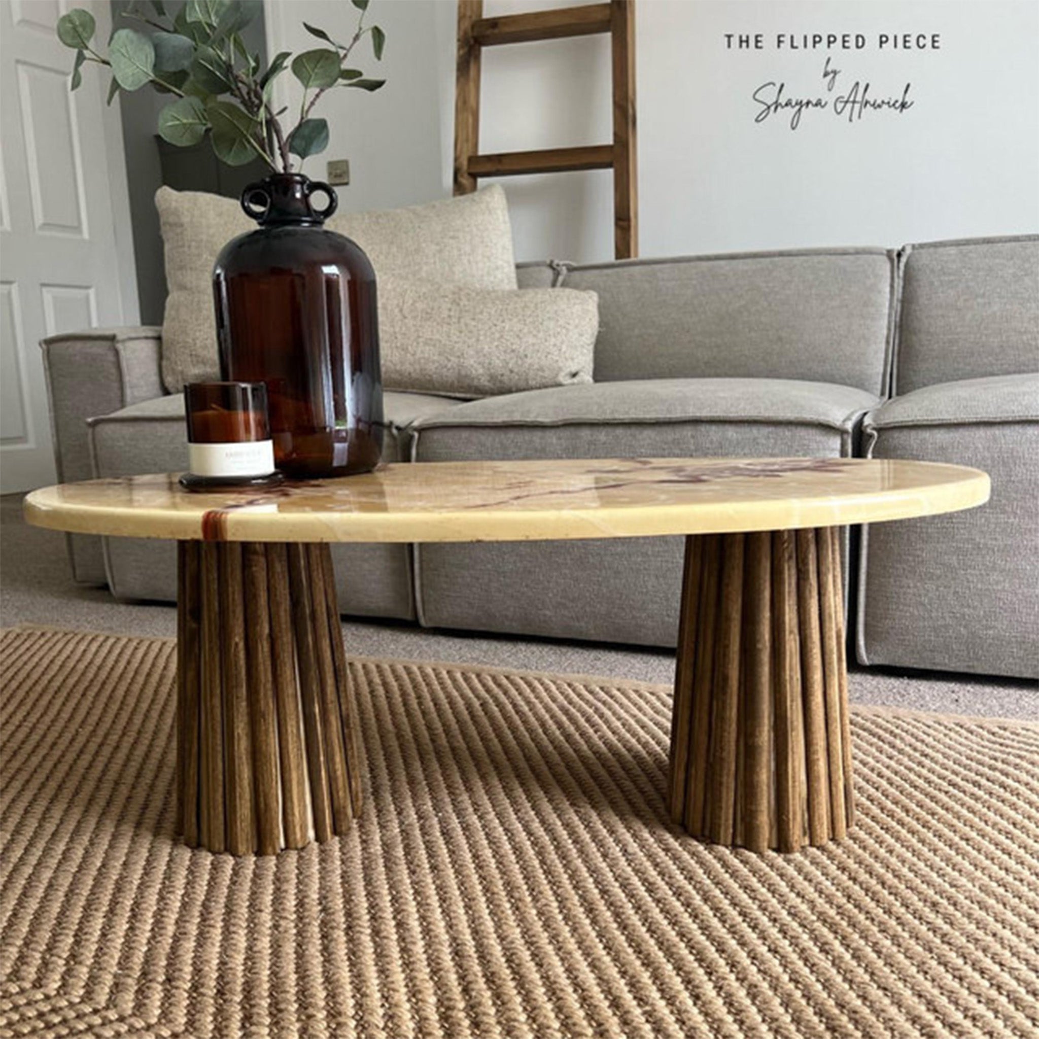 A marble coffee table refurbished by The Flipped Piece by Shayna Alnwick has wood legs that feature Dixie Belle Paint's No Pain Gel Stain.